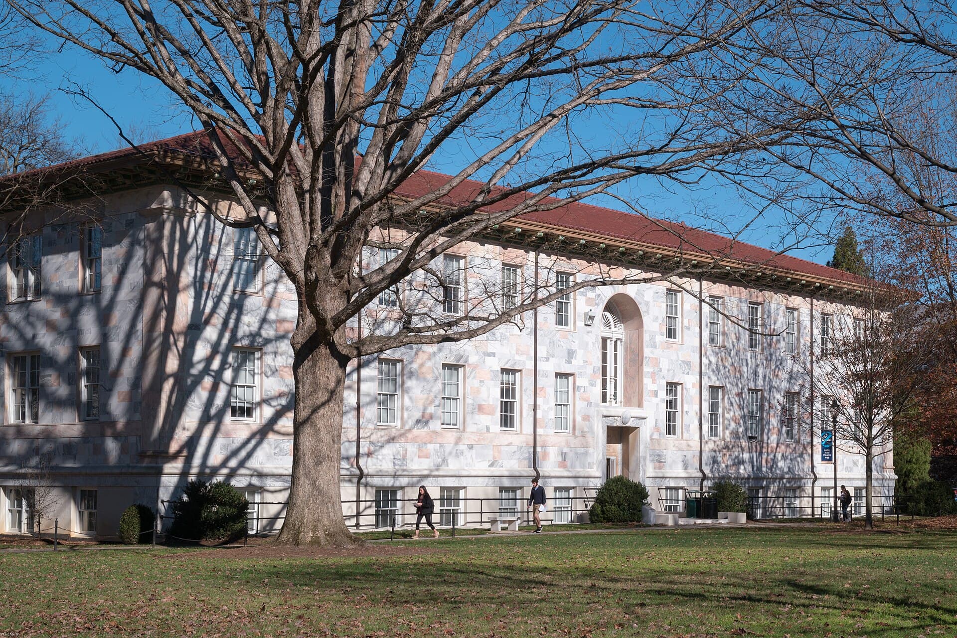 The Calloway Building's white marble facade with a red tile roof, behind a large bare tree on Emory's quad