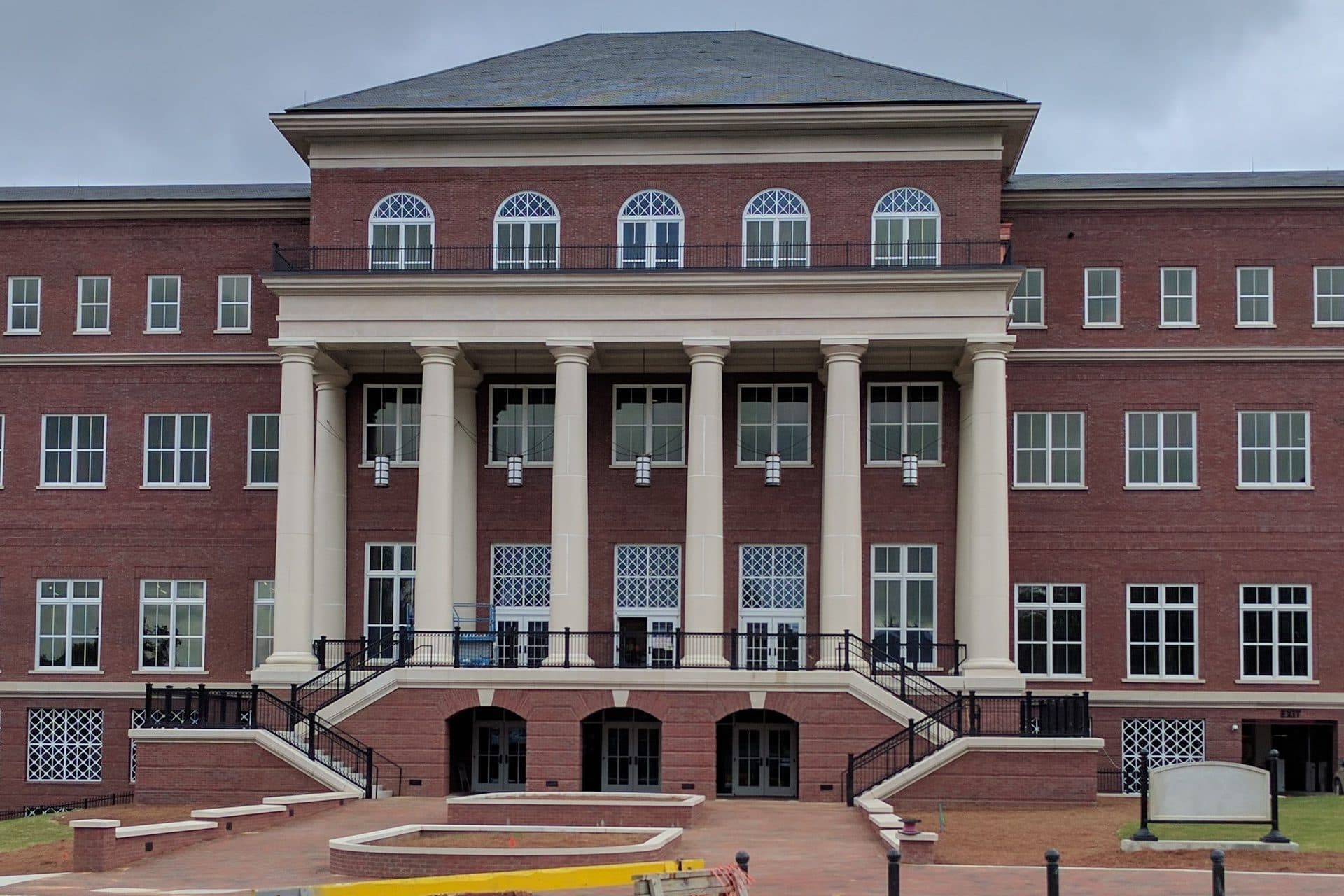The red-brick Old Main Academic Center at Mississippi State, with a white-columned portico and twin curved stairways
