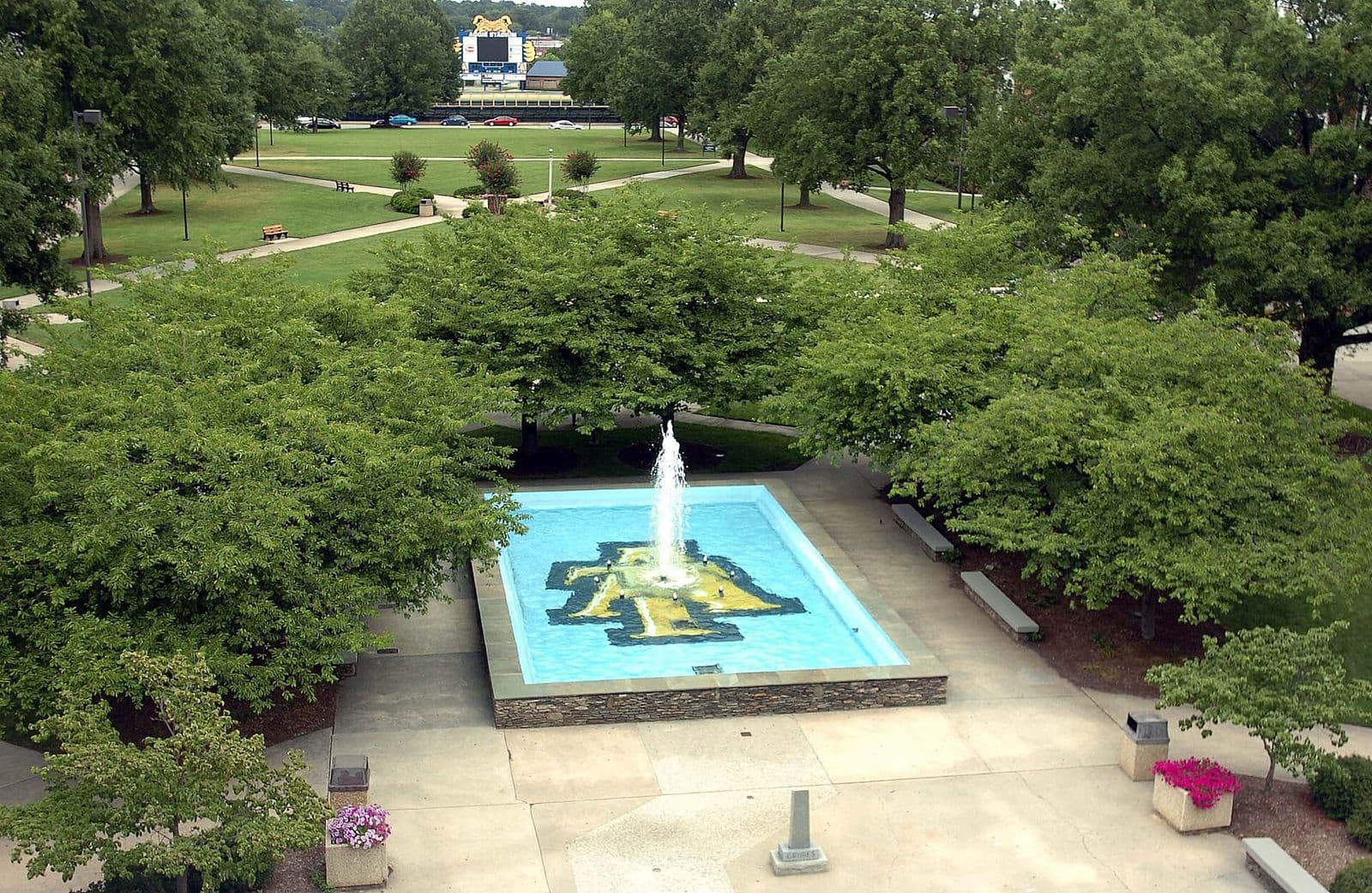 A fountain in a round pool with an Aggie logo, set in a landscaped plaza with green trees and lawns on the North Carolina A&T campus