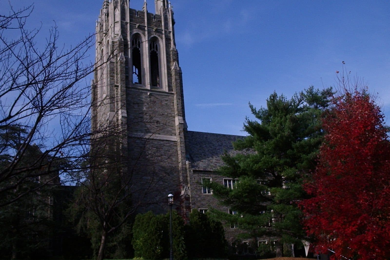 Barbelin Hall's Gothic stone tower behind a red autumn tree