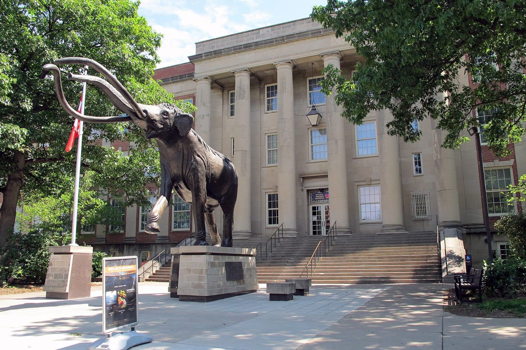 A bronze mammoth statue on Lloyd G. Tanner Plaza in front of the columned entrance of Morrill Hall at the University of Nebraska–Lincoln