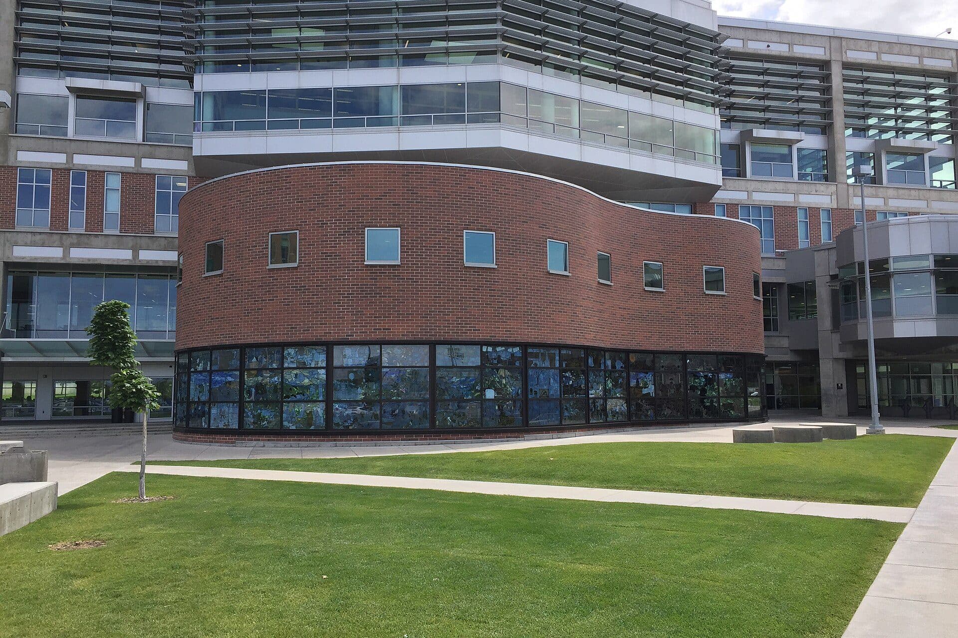 Utah Valley's Fulton Library, a rounded red-brick and glass building with the Roots of Knowledge stained glass on its ground floor