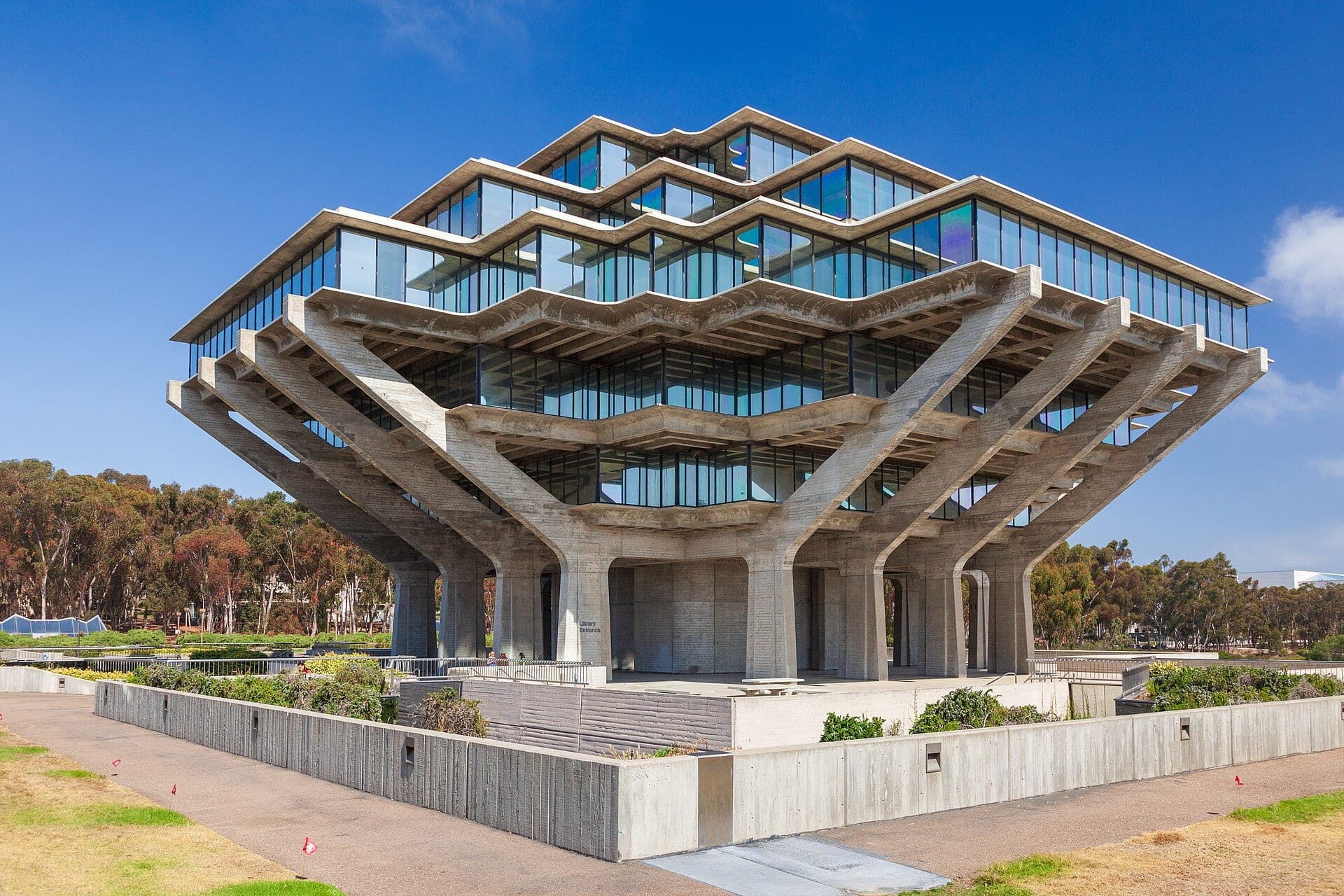 Geisel Library at UC San Diego, a tiered concrete-and-glass building on angled supports, under a blue sky